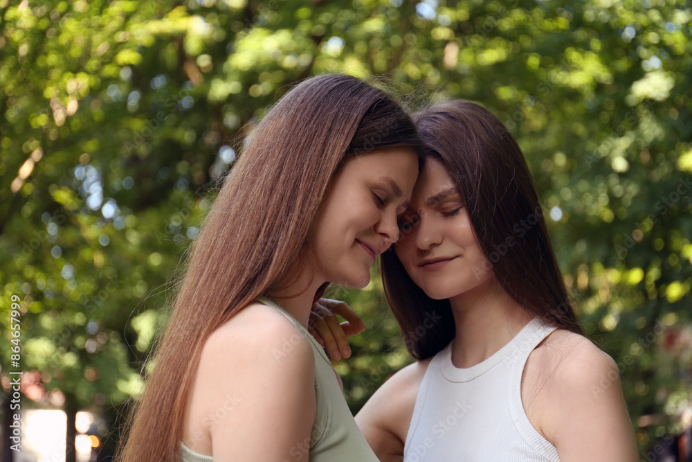 Portrait of two beautiful twin sisters in park Portrait of two beautiful twin sisters in park