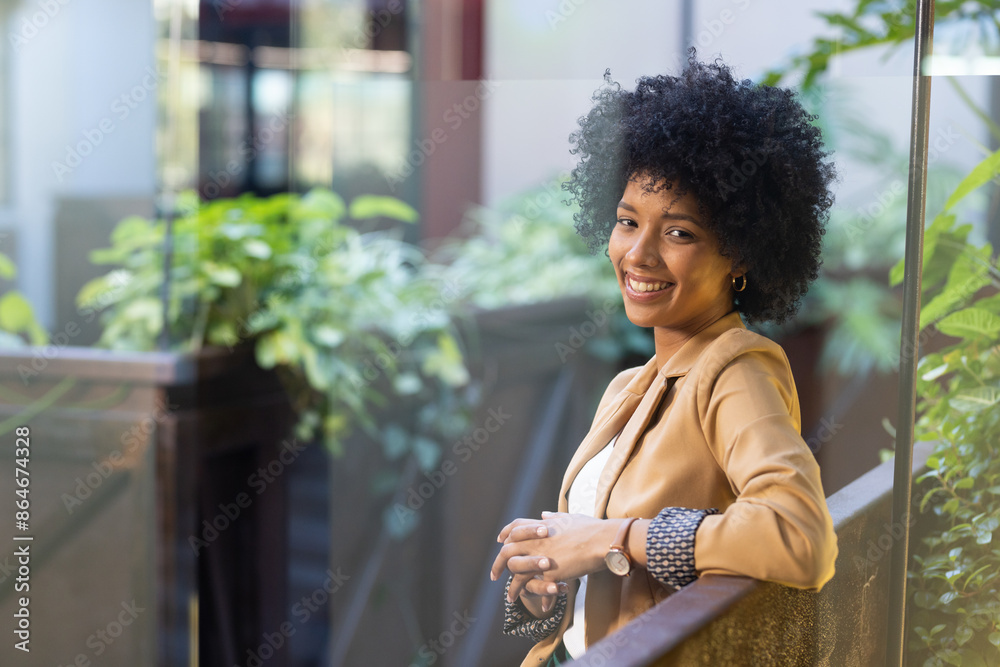Smiling businesswoman in casual attire standing outdoors, leaning on railing Smiling businesswoman in casual attire standing outdoors, leaning on railing