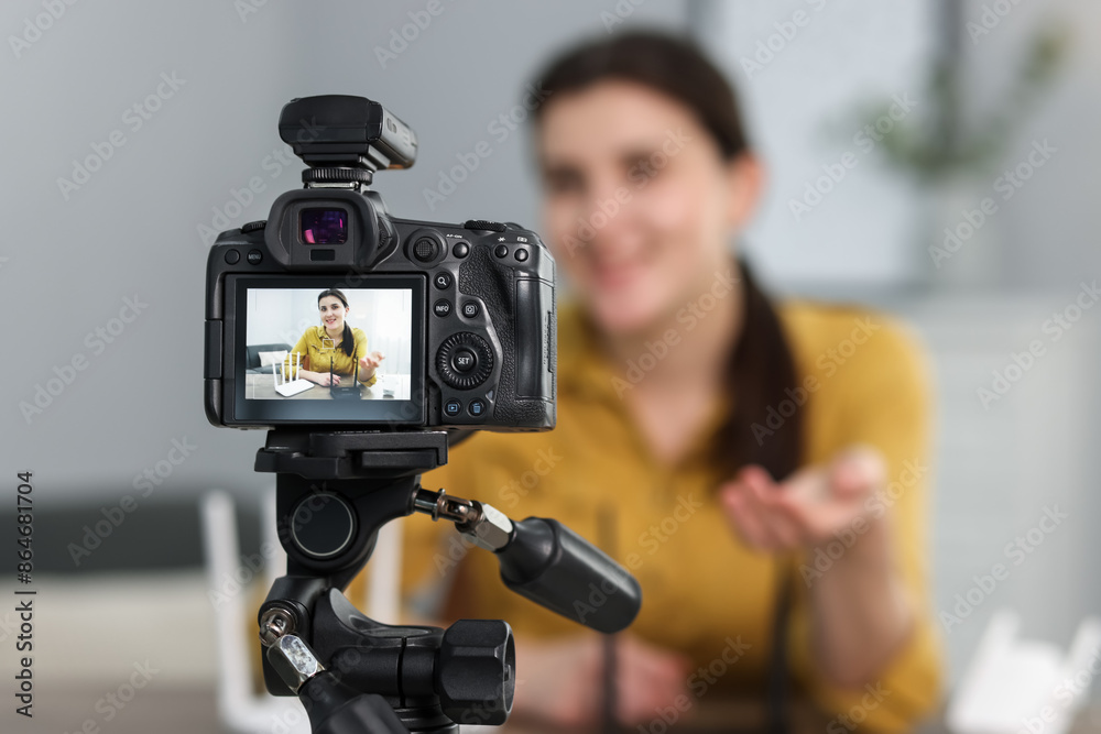 Technology blogger explaining something while recording video at home, focus on camera Technology blogger explaining something while recording video at home, focus on camera