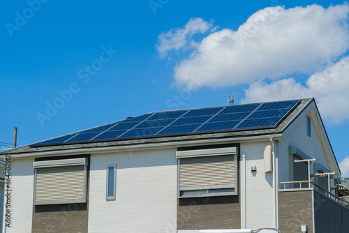 青空とソーラーパネルを設置した住宅　エコ　再生可能エネルギー