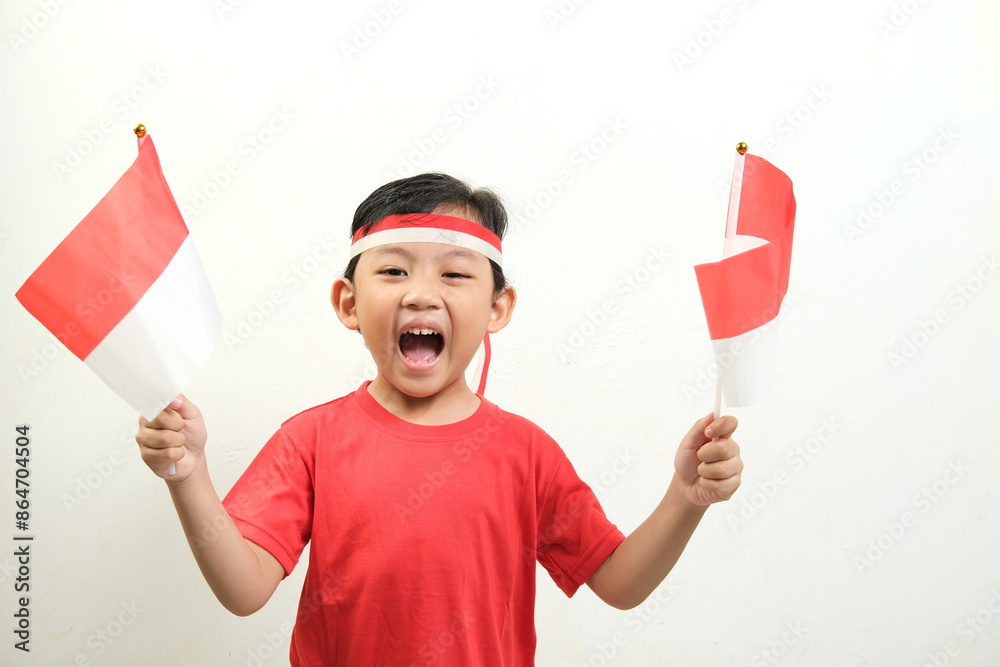 A boy energetically waves Indonesian flags,his mouth open in a shout of excitement.His enthusiasm and patriotic spirit make this image Perfect for Indonesian Independence Day, and national events. A boy energetically waves Indonesian flags,his mouth open in a shout of excitement.His enthusiasm and patriotic spirit make this image Perfect for Indonesian Independence Day, and national events.