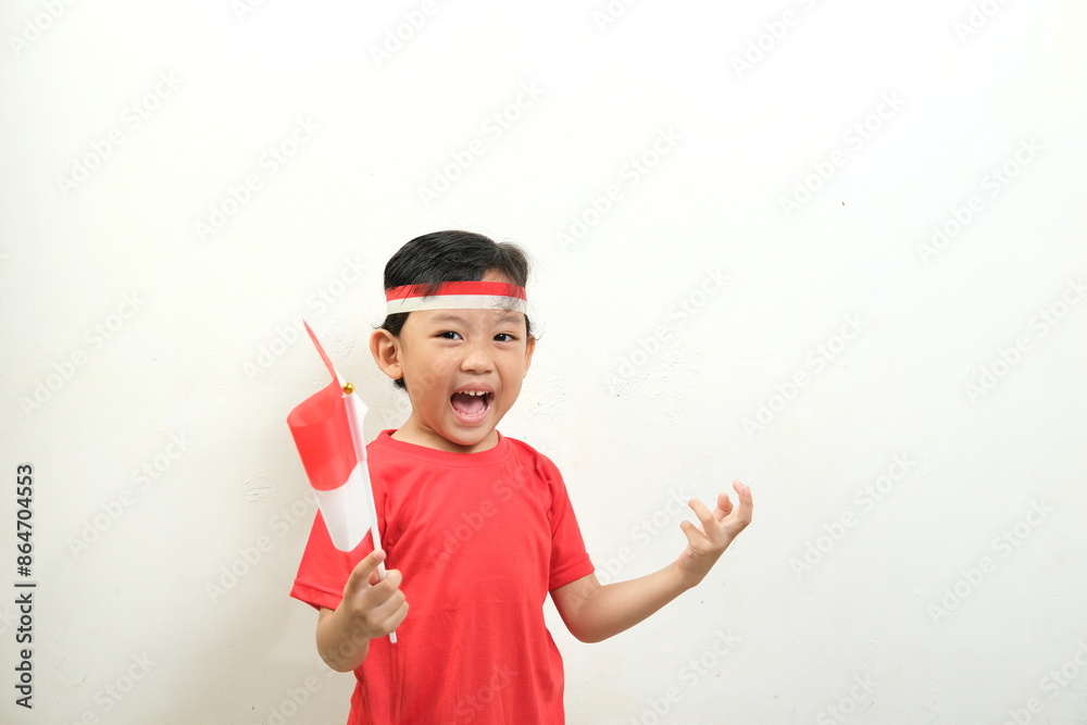 A boy energetically waves Indonesian flags,his mouth open in a shout of excitement.His enthusiasm and patriotic spirit make this image Perfect for Indonesian Independence Day, and national events.