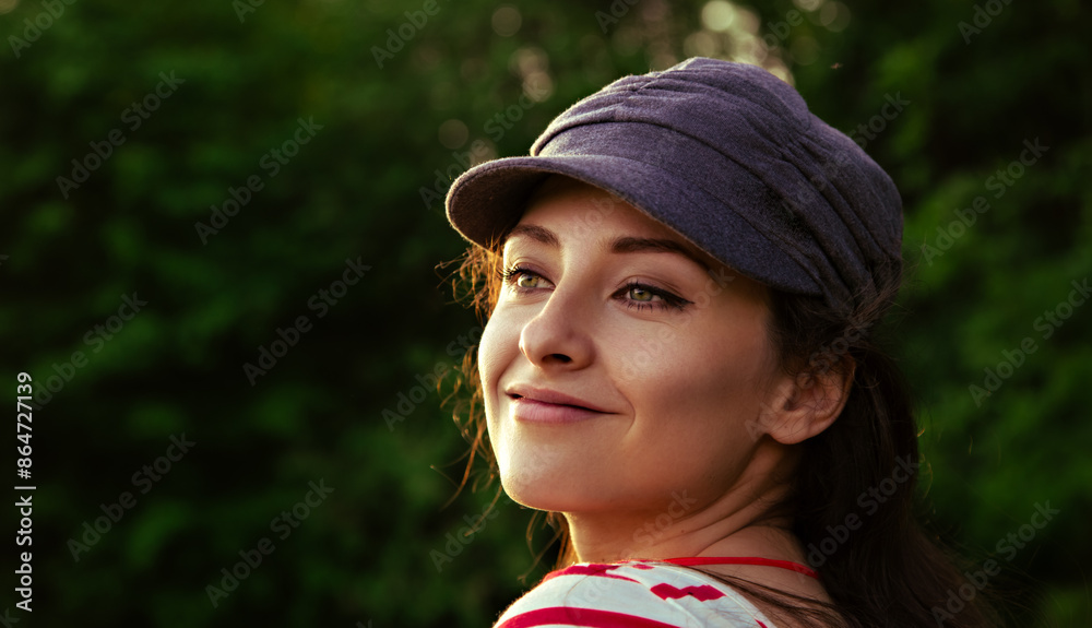 Beautiful positive dreaming smiling woman in grey cap looking outdoors summer green background. Closeup portrait Beautiful positive dreaming smiling woman in grey cap looking outdoors summer green background. Closeup portrait