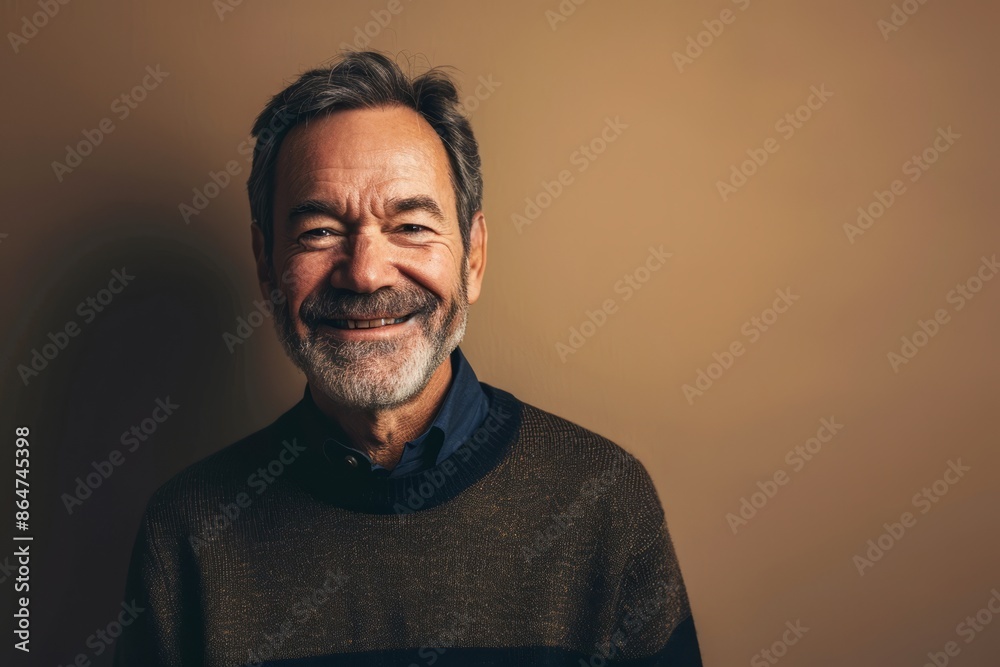 Fototapeta premium Portrait of a happy senior man smiling at the camera on a neutral background