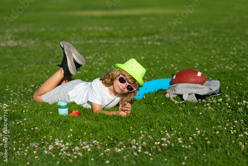 Kids playing outdoors in summer park. Freedom and carefree. Happy childhood. Relaxing kid in green field during summer. Healthy lifestyle concept. © Volodymyr