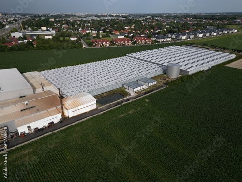 defaultAerial view of a complex of horticultural greenhouses for growing vegetables on the outskirts of a large city, growing vegetables under a glass roof. photo