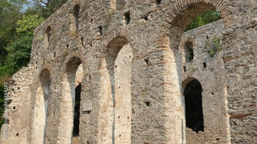 Restored old castle in Butrint in Albania. Aerial view of ruins of fortress in forest. Butrint Archaeological Park. Drone video. Butrint Albania