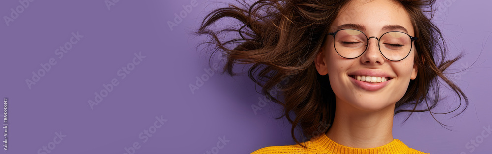 A young woman wearing glasses and a yellow sweater smiles happily A young woman wearing glasses and a yellow sweater smiles happily
