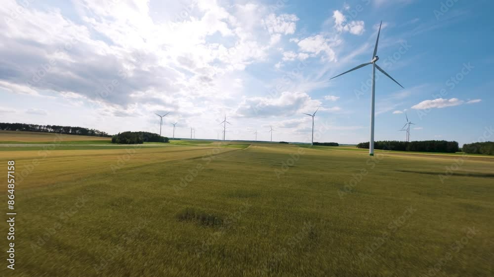 Green fields with wind turbines on sunny day, aerial FPV view Green fields with wind turbines on sunny day, aerial FPV view