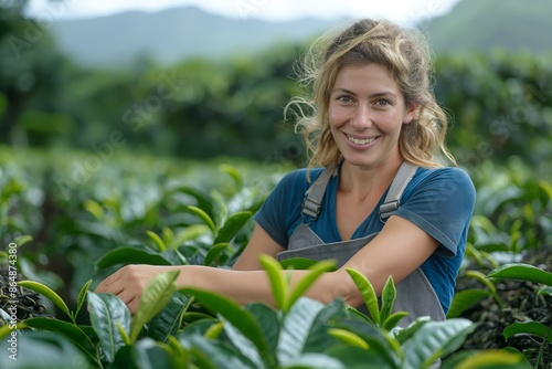 Cheerful woman with an apron working and smiling in a green tea field