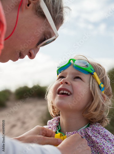 Mother tending to young daughter on the beach photo