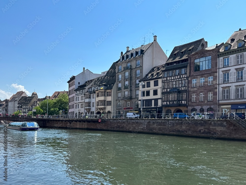 Naklejka premium Sightseeing boat is touring Ill river along Quai Saint-Nicolas in Strasbourg, Grand Est, France, June 2023