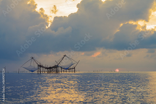 Yor Yak or Thai giant fishing gear with golden morning light, and beautiful sunrise scenery at Pakpra canal, Phatthalung, Thailand. photo