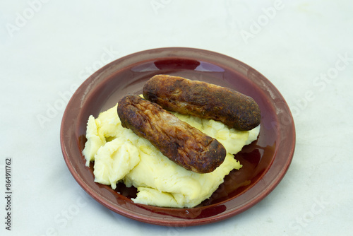 Bangers and mash on a plate isolated on a clear background with copy space