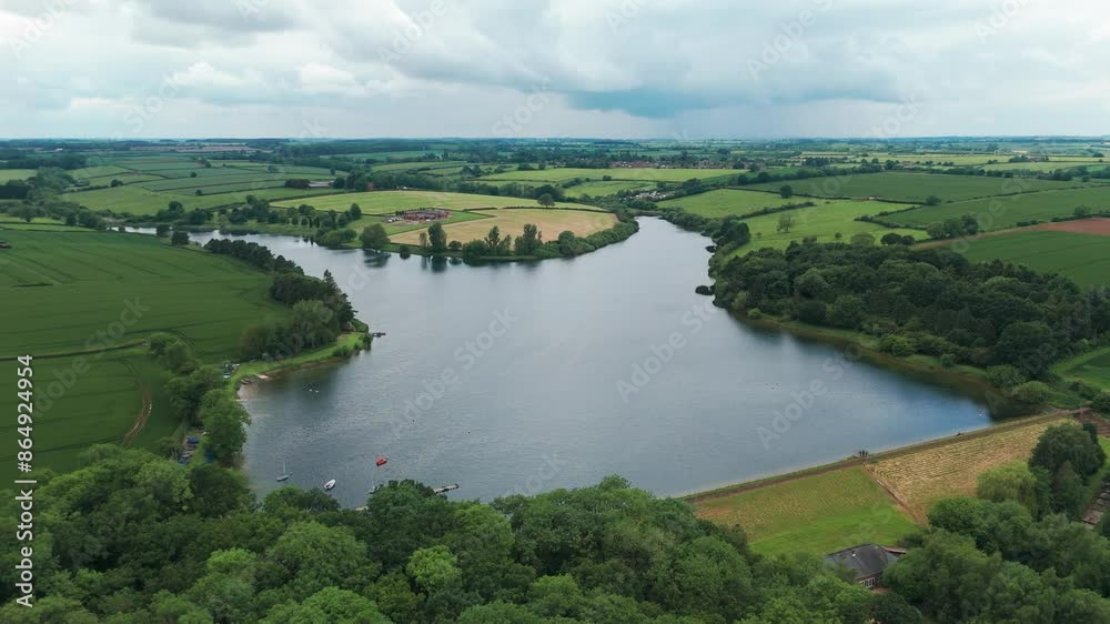 Rotating drone view of Cransley Reservoir with reflection of sky in water in England. Rotating drone view of Cransley Reservoir with reflection of sky in water in England.
