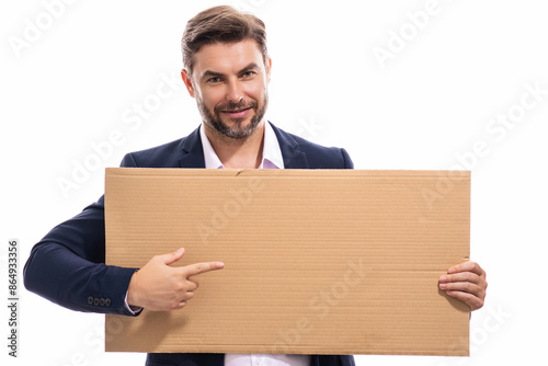 Happy man with blank banner isolated on studio background. Portrait of attractive man with empty blank poster. Man showing poster, pointing finger on signboard placard. Billboard or banner concept. © Volodymyr