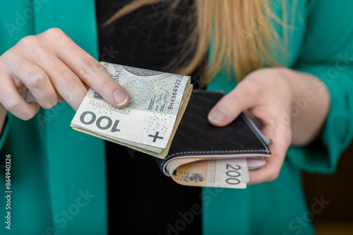 Kobieta z grubym portfelem płaci za zakupy, polska gotówka  photo