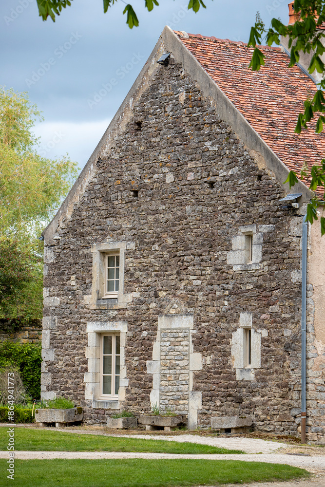 Façade d'une grande maison en pierre, avec deux larges fenêtres et deux plus petites. Une porte condamnée avec des pierres. Façade d'une grande maison en pierre, avec deux larges fenêtres et deux plus petites. Une porte condamnée avec des pierres.