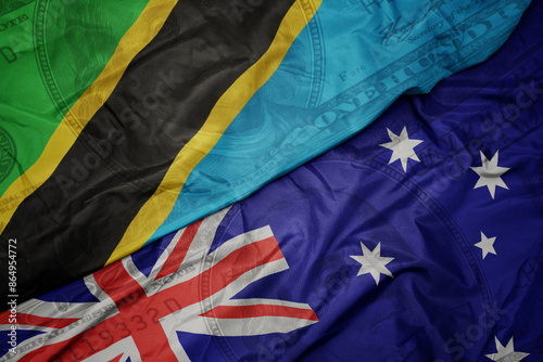 waving colorful flag of tanzania and national flag of australia on the dollar money background. finance concept. photo