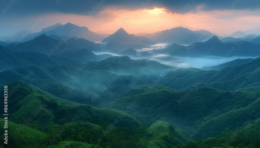 Fototapeta premium A mesmerizing view of lush green hills and undulating mountain ranges kissed by the glow of a setting sun, with mist filling the valleys and adding a mystical touch to the scene.