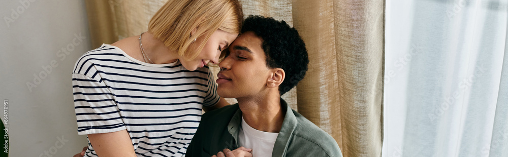 A young multicultural couple shares an intimate moment in their modern apartment. A young multicultural couple shares an intimate moment in their modern apartment.
