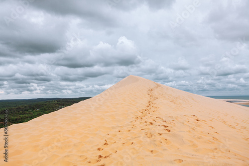 Dune of Pilat in France, the tallest sand dune in Europe.  Sandy hill with a cloudy sky in the background. Breathtaking views of sand hill surrounding by pine forest photo