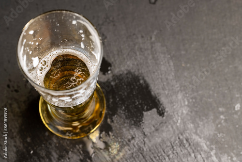 light golden beer in a glass glass on a black background photo