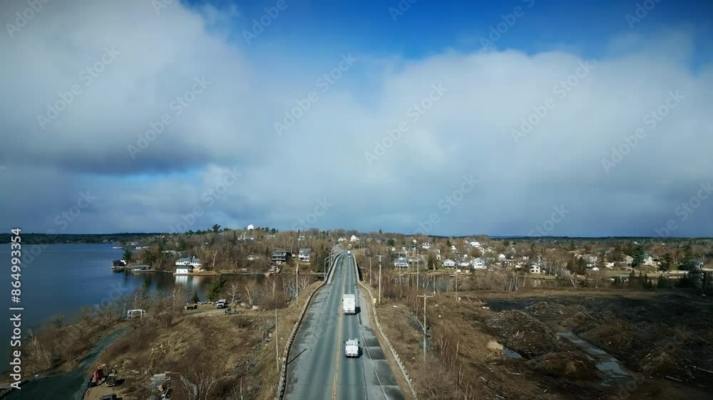 Drone Shot White Truck Drives across Elevated Lake Bridge in Countryside Drone Shot White Truck Drives across Elevated Lake Bridge in Countryside