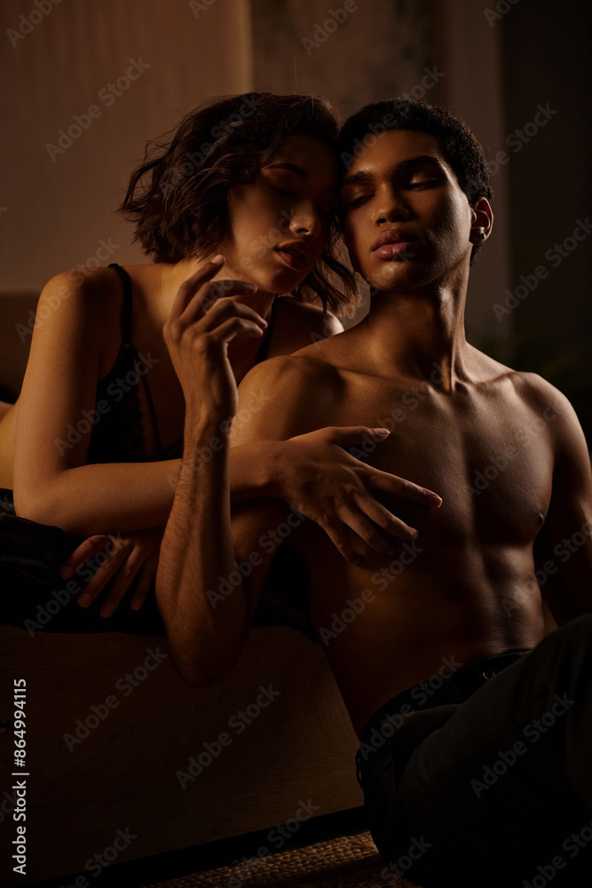 A young Asian woman in black lingerie embraces a Black man on a bed. Their passionate embrace is captured in a romantic setting. A young Asian woman in black lingerie embraces a Black man on a bed. Their passionate embrace is captured in a romantic setting.