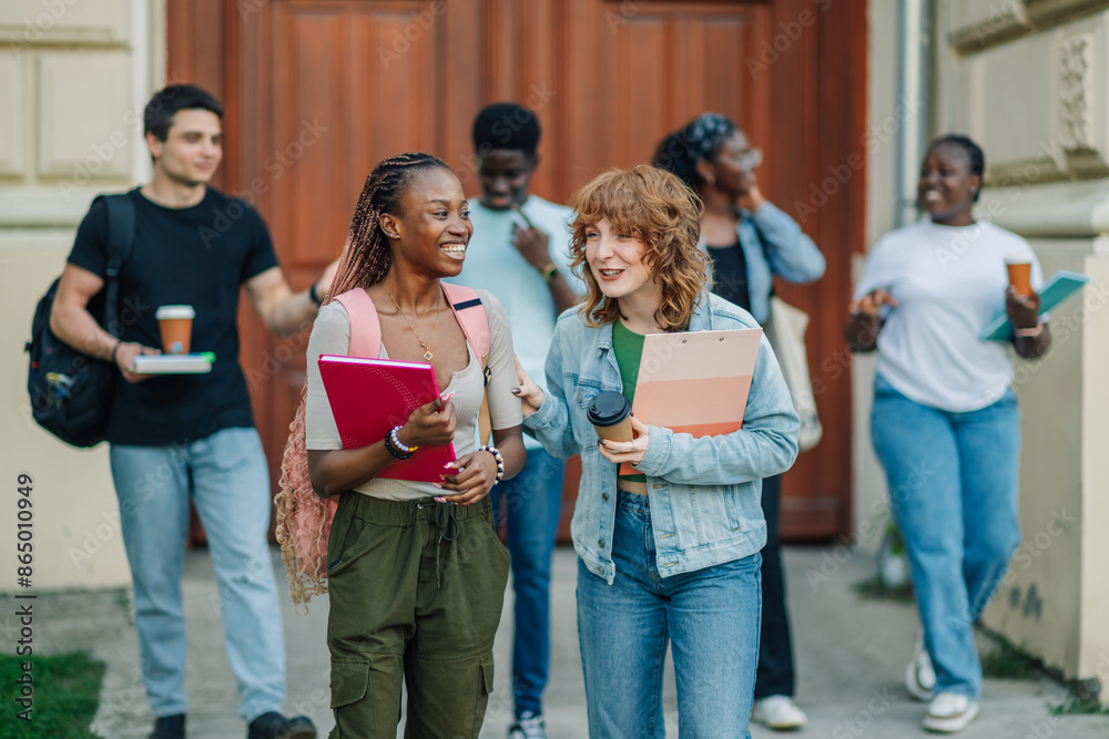 Diverse college students exiting university building and going on break Diverse college students exiting university building and going on break