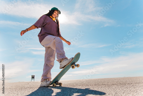 Young woman skateboarding on sunny day photo