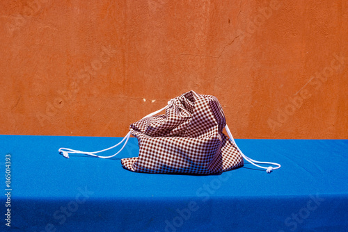 Red check fabric cloth drawstring bag kept on table