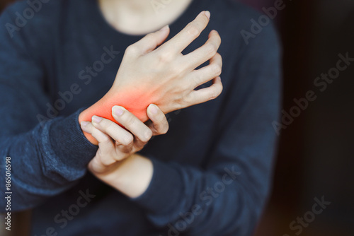 Person holding wrist in pain, highlighting wrist pain and discomfort. Concept of injury, arthritis, or carpal tunnel syndrome.