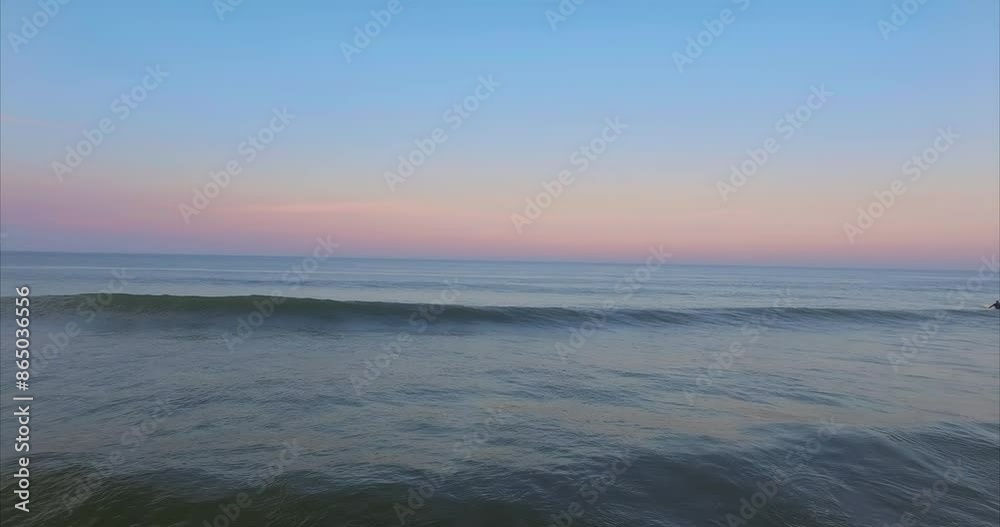 Calm ocean waves crashing on a beach at sunset in Cape Cod, Massachusetts, United States of America. Calm ocean waves crashing on a beach at sunset in Cape Cod, Massachusetts, United States of America.