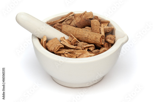 Close-up of Dry Organic Lodhra Barks (Symplocos racemosa), in white ceramic mortar and pestle, isolated on a white background. photo