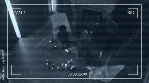 Overhead CCTV shot of three teens sitting on floor among lit candles and reading incantations from occult book, invoking dark forces who live in dark desolate mansion