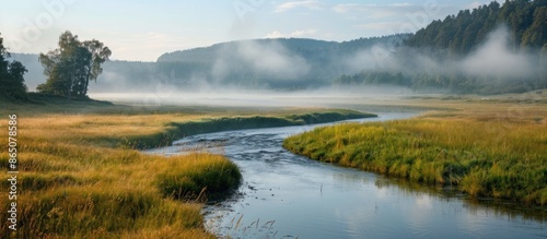 Serene River Flowing Through Misty Valley