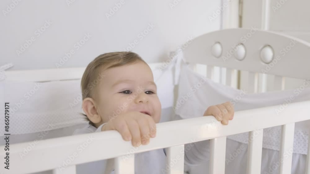 Joyful adorable baby boy in crib. Smiling toddler standing in bed at home. Joyful adorable baby boy in crib. Smiling toddler standing in bed at home.