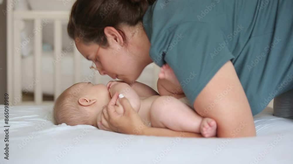 Mother playing on bed with adorable newborn baby boy. Family concept Mother playing on bed with adorable newborn baby boy. Family concept