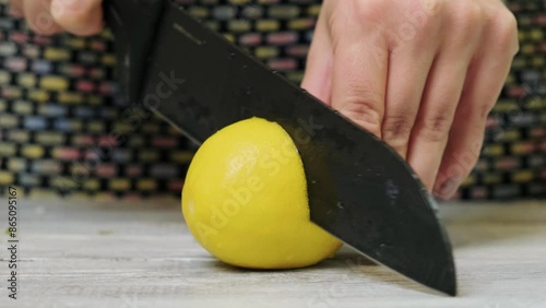 CLose up showing a woman cutting lemon in her kitchen. Slow motion