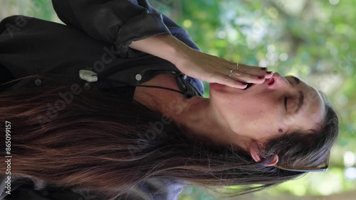 Vertical shot of young woman yawning widely