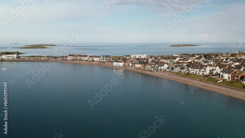 Aerial Left to Right Motion Over Skerries Coastline and Town in Dublin, Ireland with Clear Blue Waters and Residential Areas