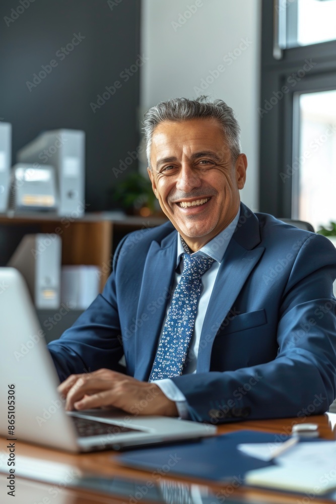 Man sitting at a desk with a laptop computer Man sitting at a desk with a laptop computer