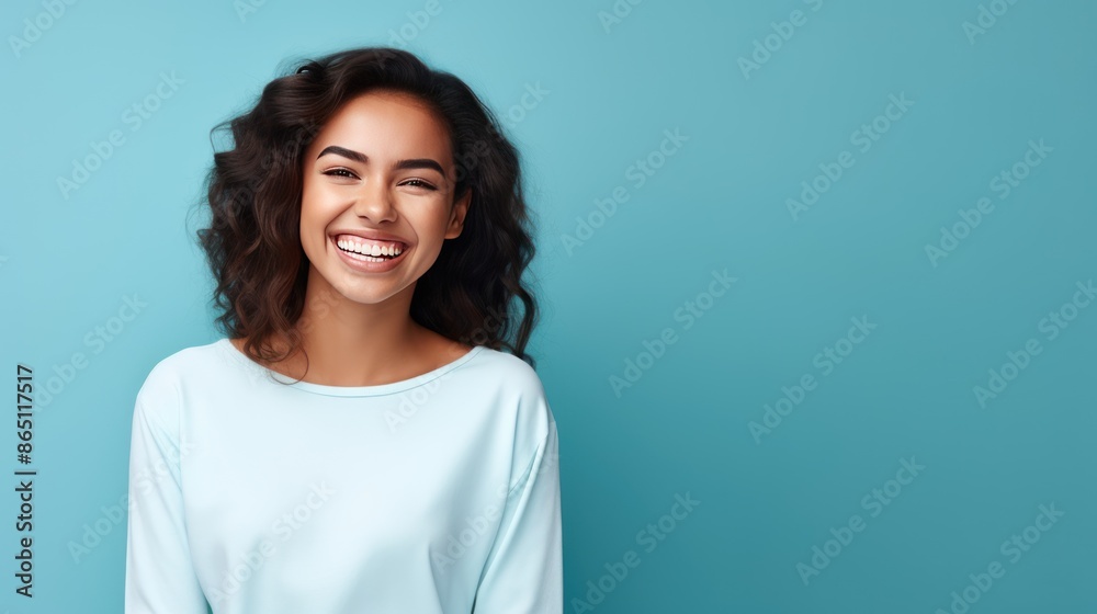 Joyful young woman with a bright smile on blue  background, 