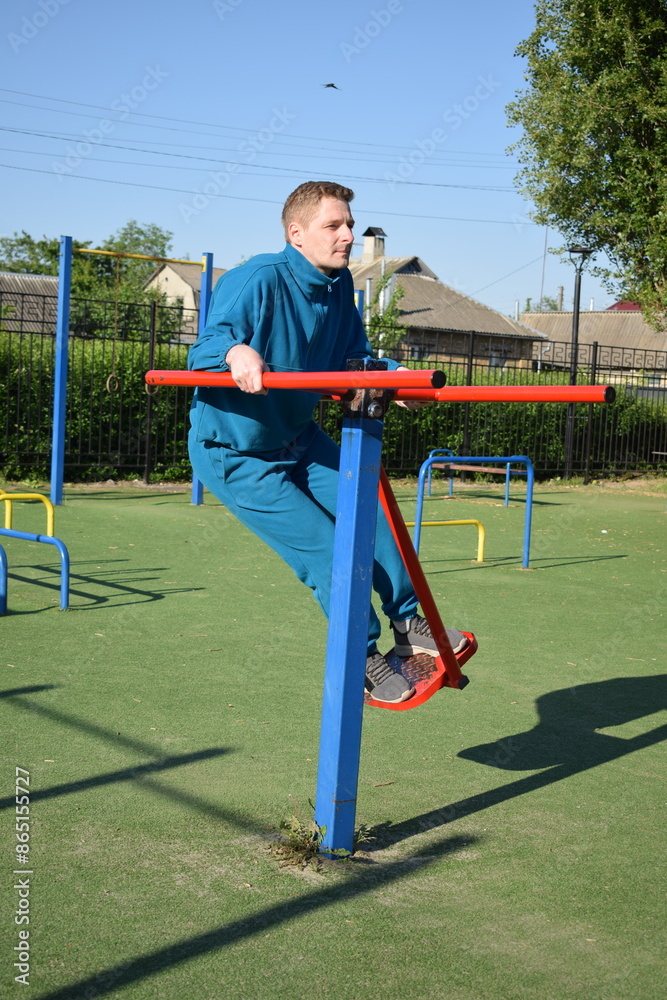 Fototapeta premium A dedicated young athlete puts in the hard work, vigorously training on gym equipment outdoors to prepare his body. He builds strength and endurance before hitting the field or court for competition