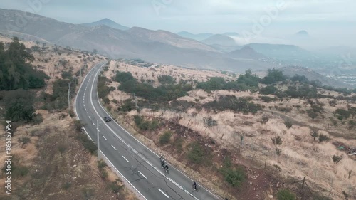 cyclists pedaling at high speed over the top of a hill in the municipality of Barnechea, Chile photo