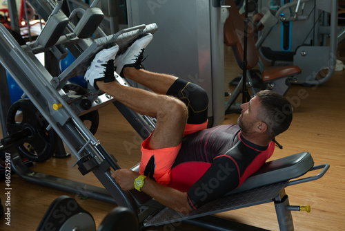 Fotografía Man performing leg press exercise in the gym