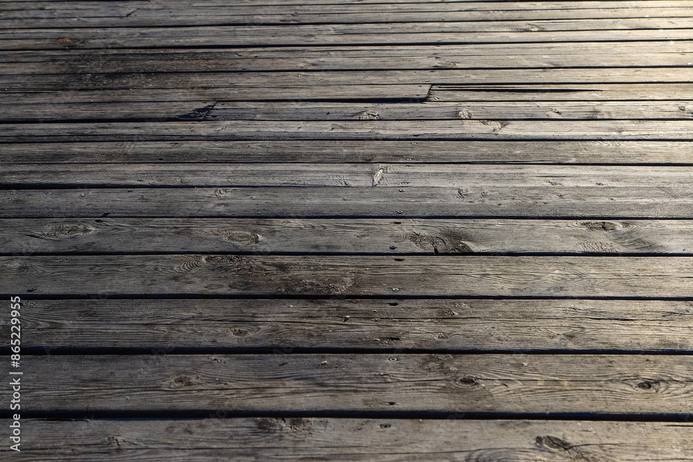 Obraz premium An old wooden pavement in sunset light as a background. Photo in perspective with selective focus