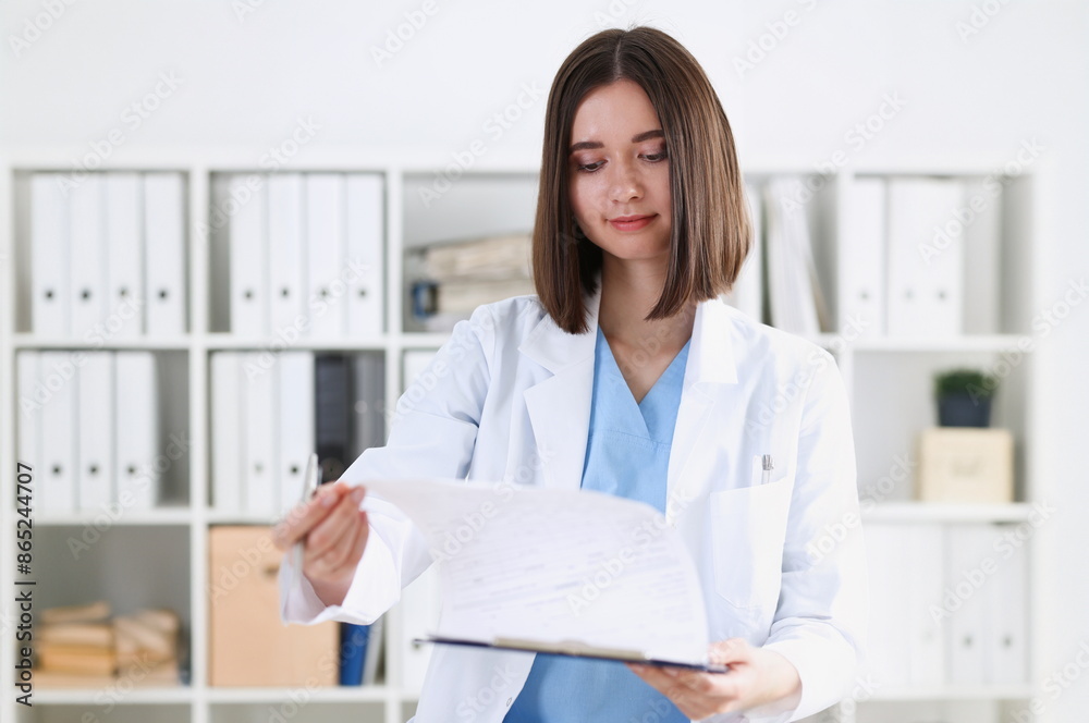 Female medicine doctor hand holding silver pen looking in clipboard pad closeup. Ward round patient visit check 911 medical calculation and statistics concept. Physician ready to examine patient Female medicine doctor hand holding silver pen looking in clipboard pad closeup. Ward round patient visit check 911 medical calculation and statistics concept. Physician ready to examine patient