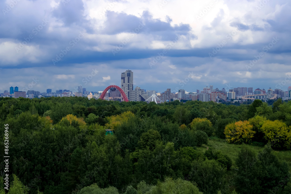 An impressive blend of nature and urban architecture, featuring a striking red arch bridge amidst lush greenery, with a backdrop of city skyscrapers under a dramatic, cloudy sky An impressive blend of nature and urban architecture, featuring a striking red arch bridge amidst lush greenery, with a backdrop of city skyscrapers under a dramatic, cloudy sky